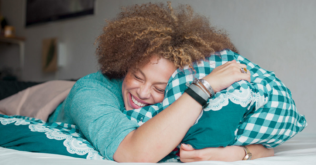 happy-woman-with-closed-eyes-holding-pillow-1200x628-facebook-1200x628-9546353